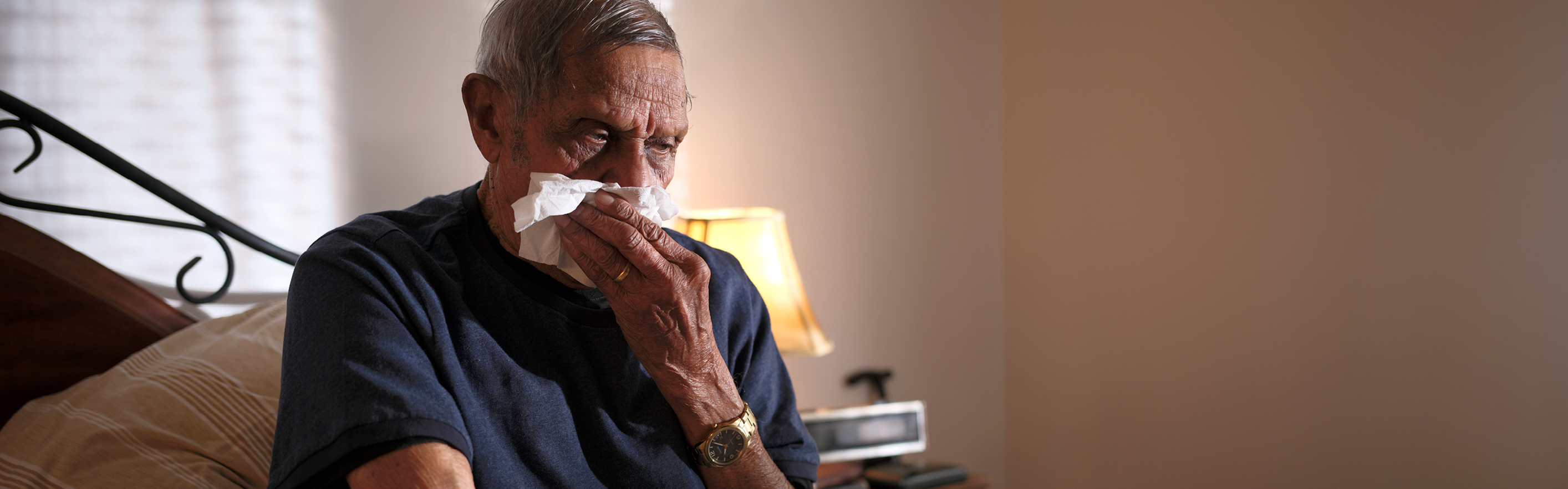 older man blowing nose